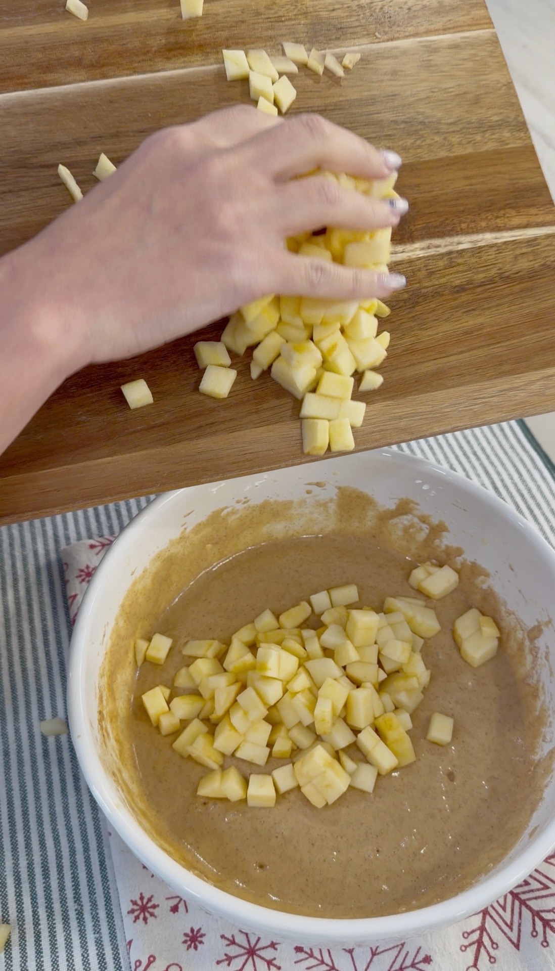 Adding peeled, diced apples to the muffin batter