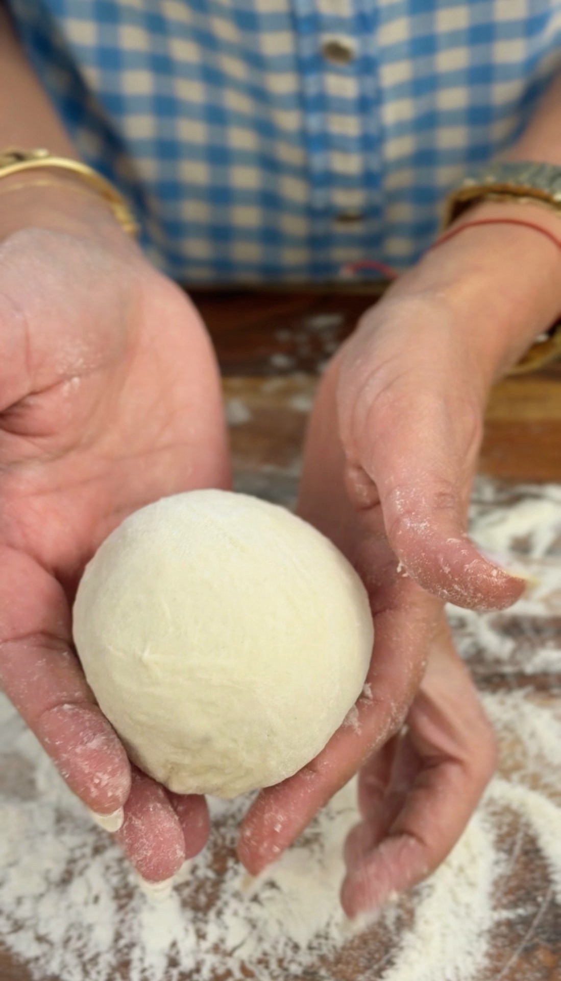 Holding a smooth, rounded portion of dough in floured hands
