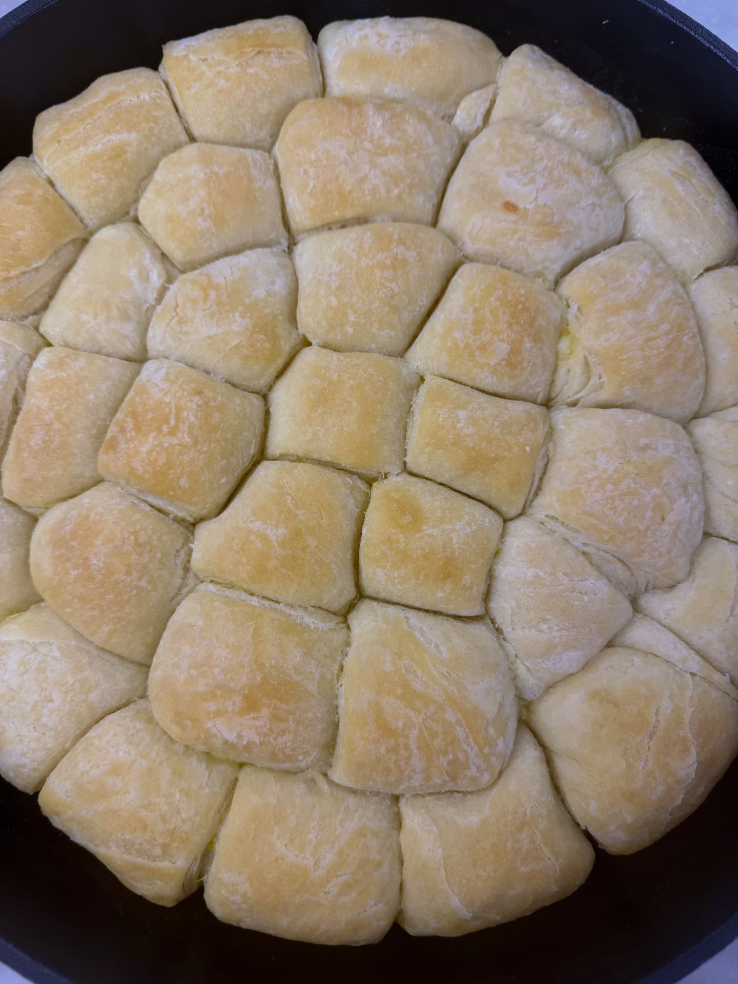 Close-up of the buttery layered tops of baked tutmanik rolls