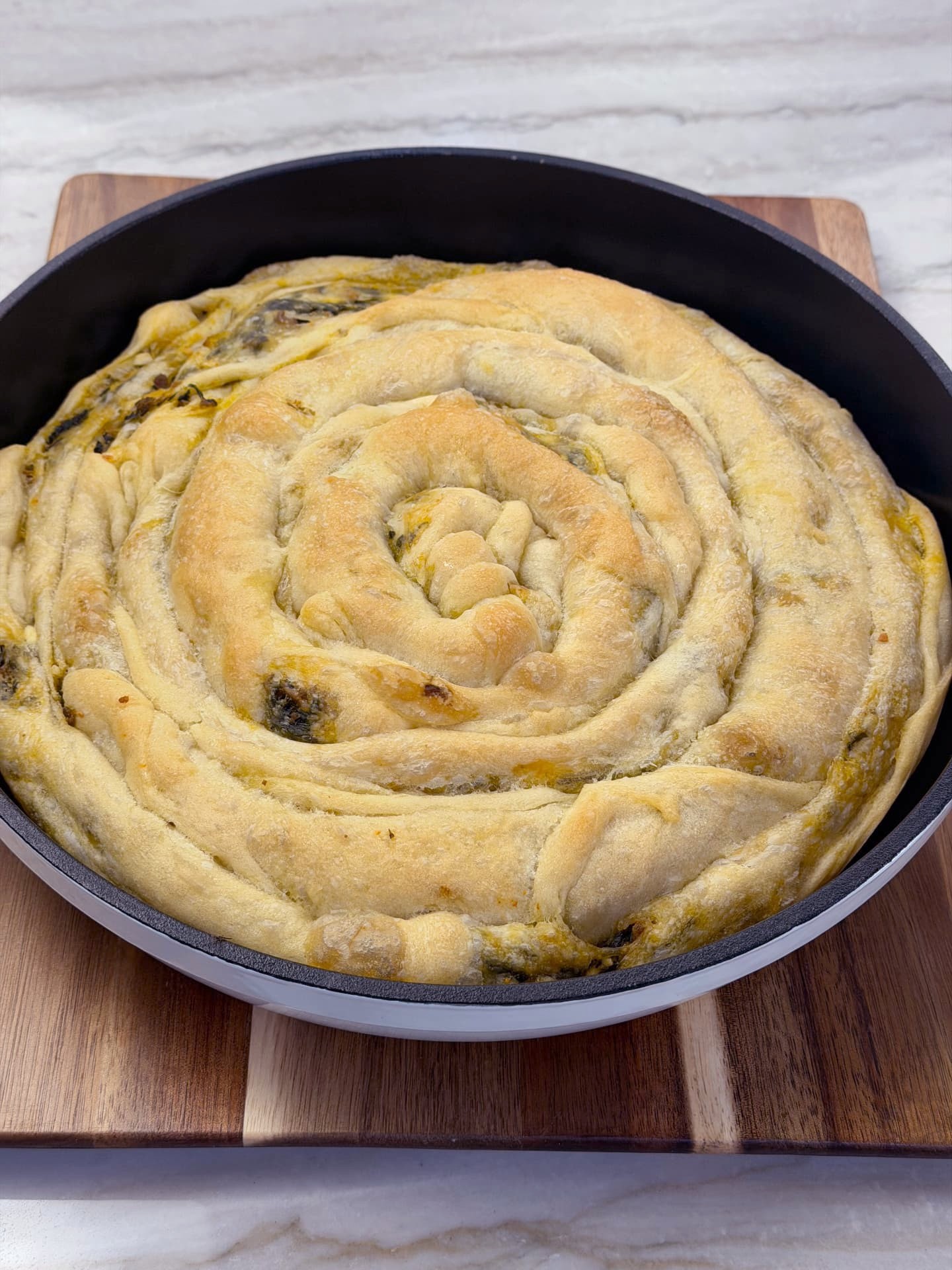 The baked banitsa seen from the side, showing its golden crust