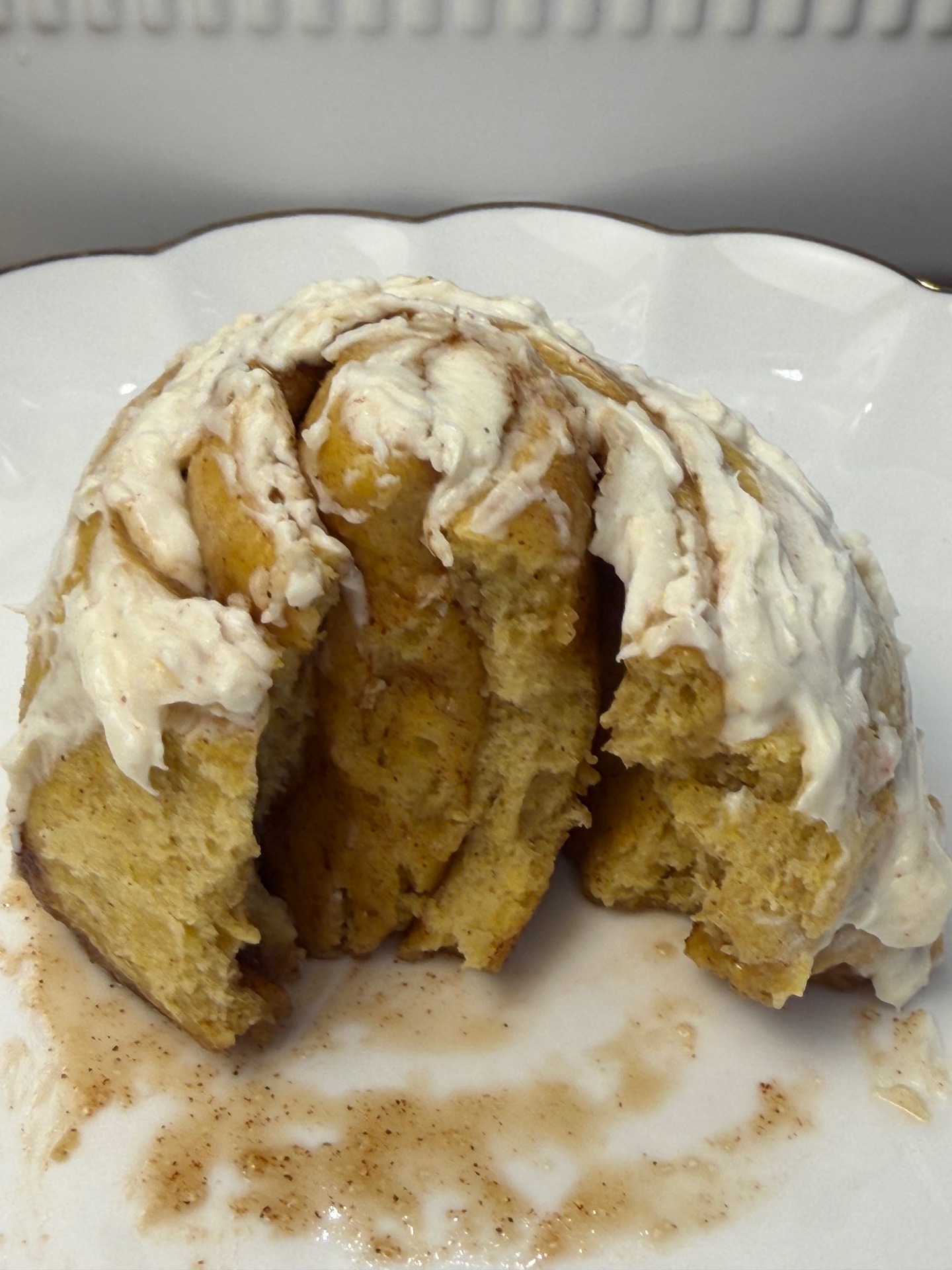 Cut pumpkin cinnamon roll showing the soft inside and cinnamon layers