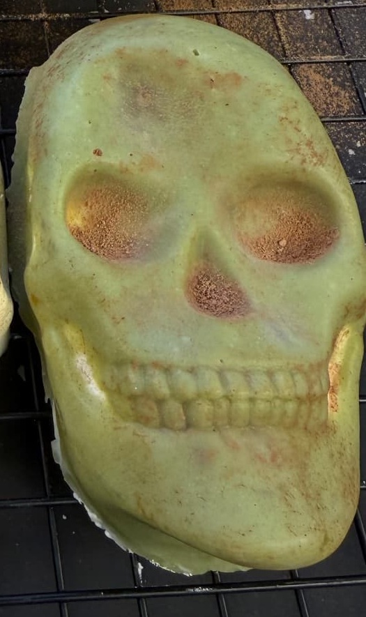 Close-up of the green matcha candy-coated skull treat dusted with cocoa powder
