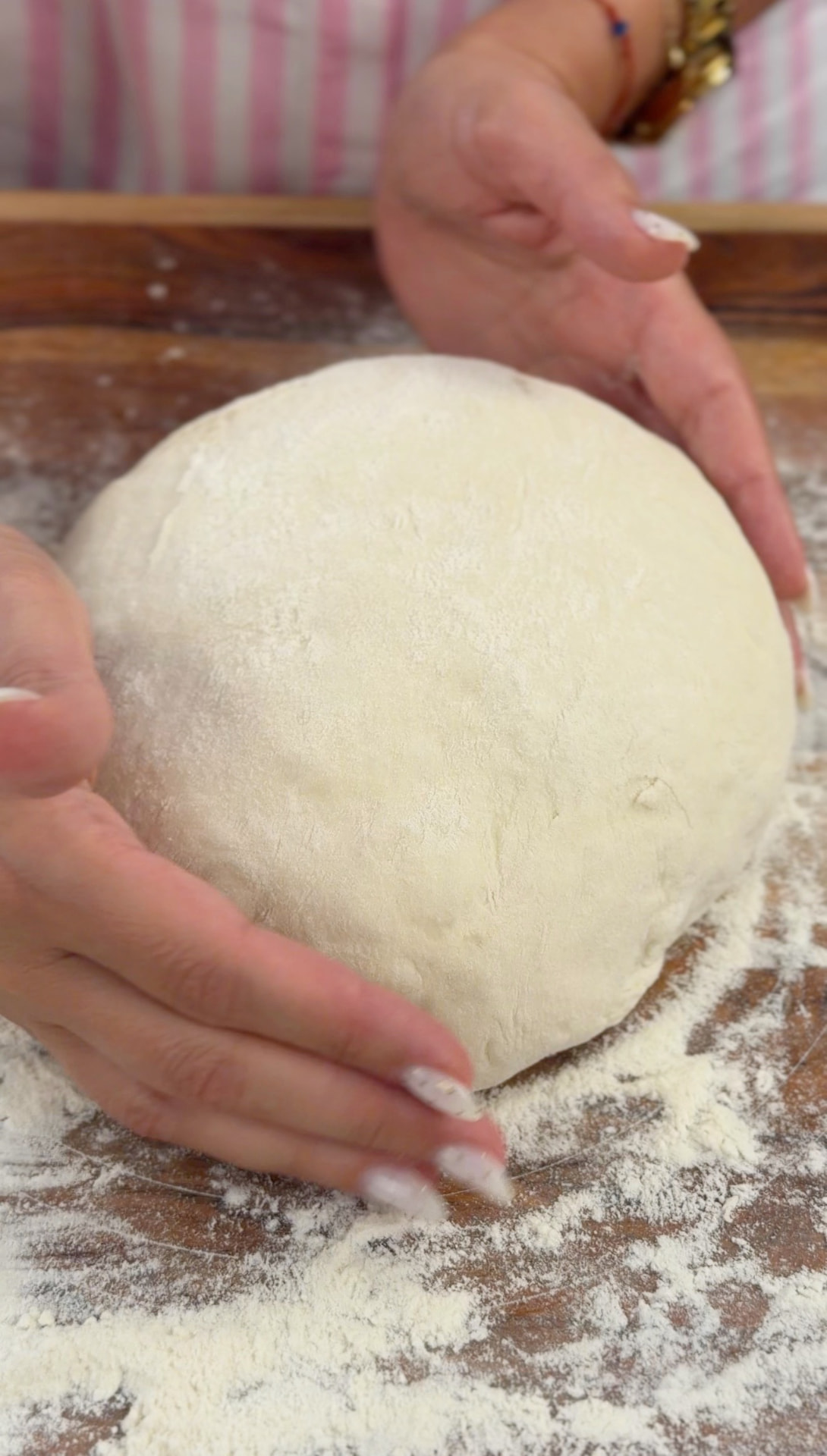 Shaping the soft kneaded dough into a ball on a floured board